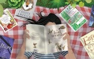 Illustrtion of a woman lying on a blanket in the grass reading books.