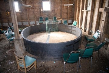 A circular cockfighting pit surrounded by chairs where crowds would watch.