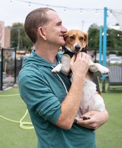 Biscuit the beagle being held by his owner.