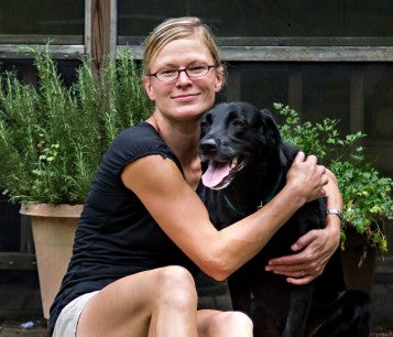 Woman and her black dog on back porch of their home